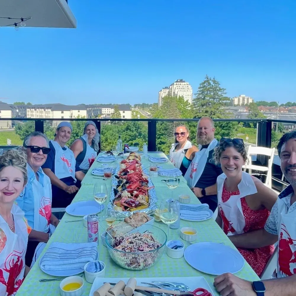 Guests seated at a long rooftop table for a Monarch Culinary catered seafood dinner