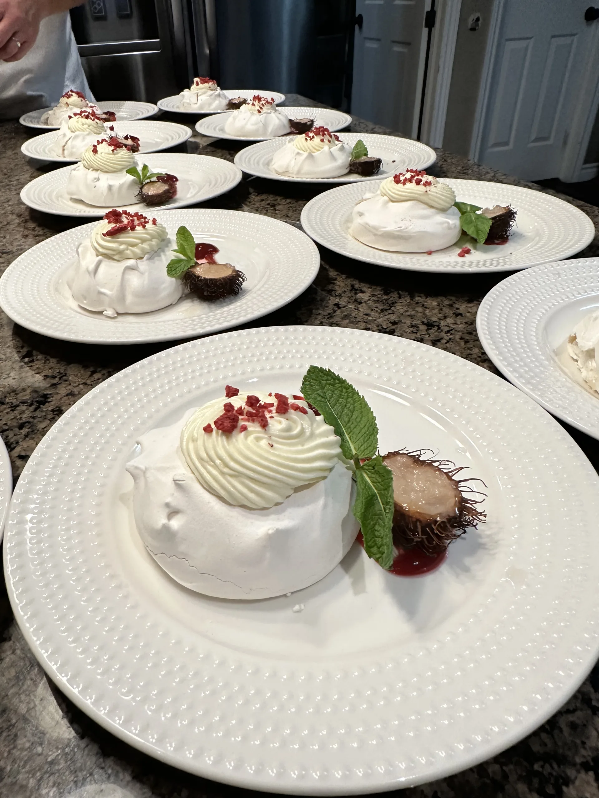 Plated pavlova desserts lined up ready for service