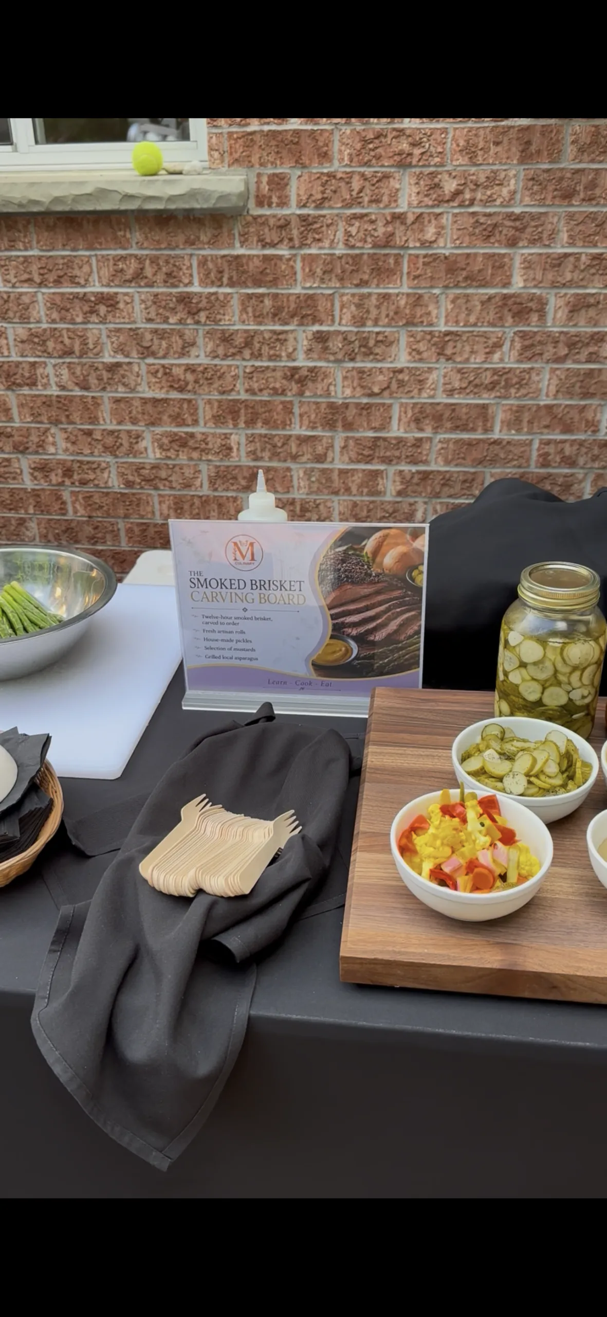 Grazing table with preserves and snacks set against a brick wall
