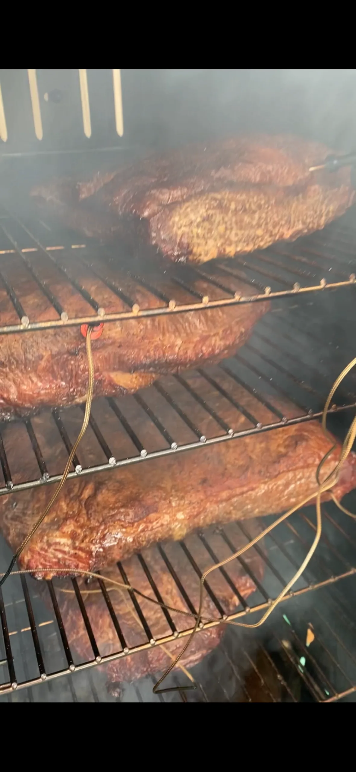 Racks of ribs cooking on the grill at a Monarch Culinary event
