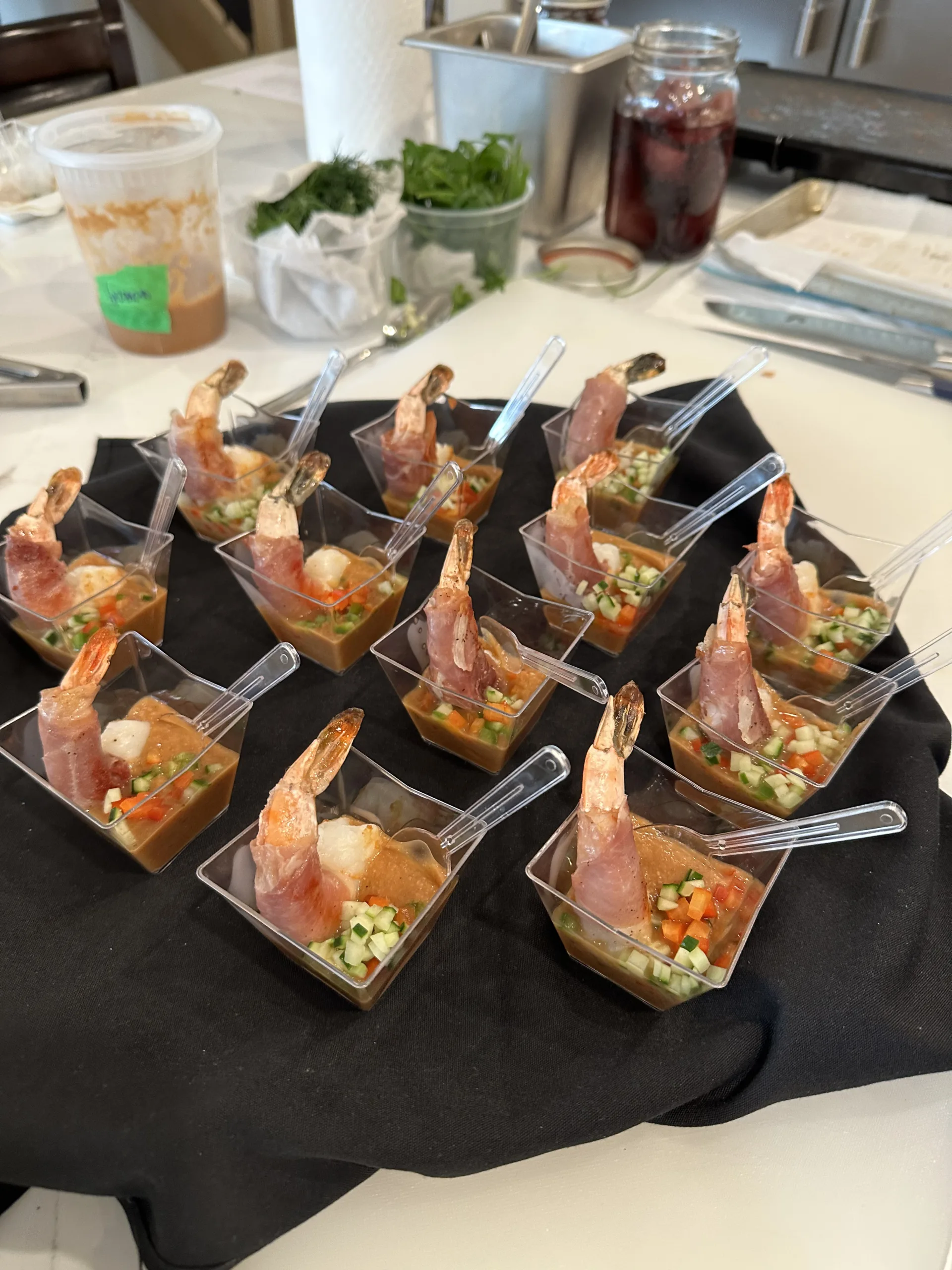 Shrimp cocktail canapes served in individual cups on a black tray