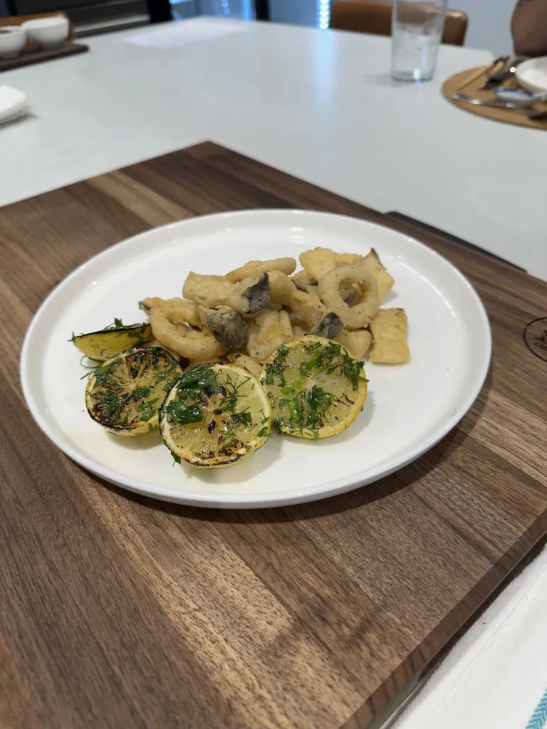 Roasted potatoes and grilled courgette with herbs, plated on a walnut board