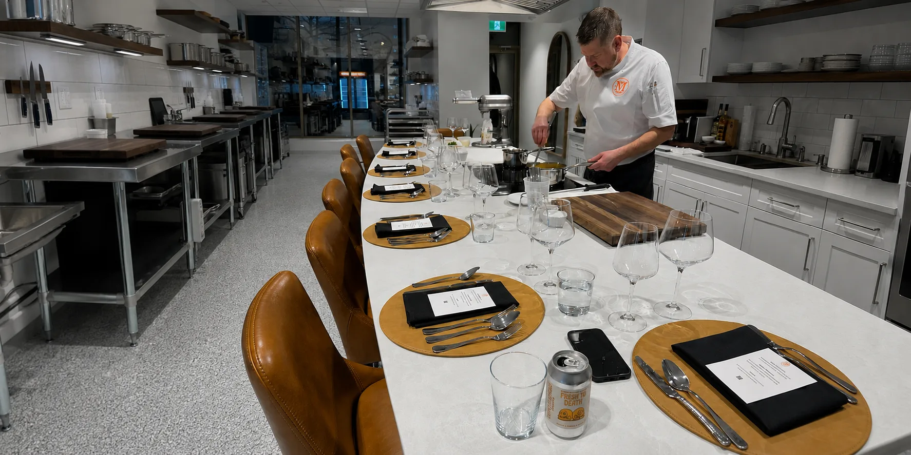 Chef plating at the Monarch Culinary Studio chef's table, set for a corporate dinner
