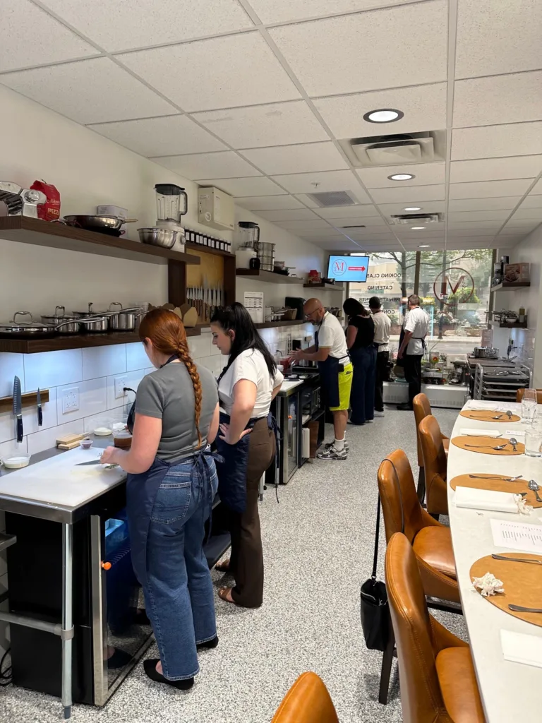 Guests preparing food together at a Monarch Culinary group cooking night