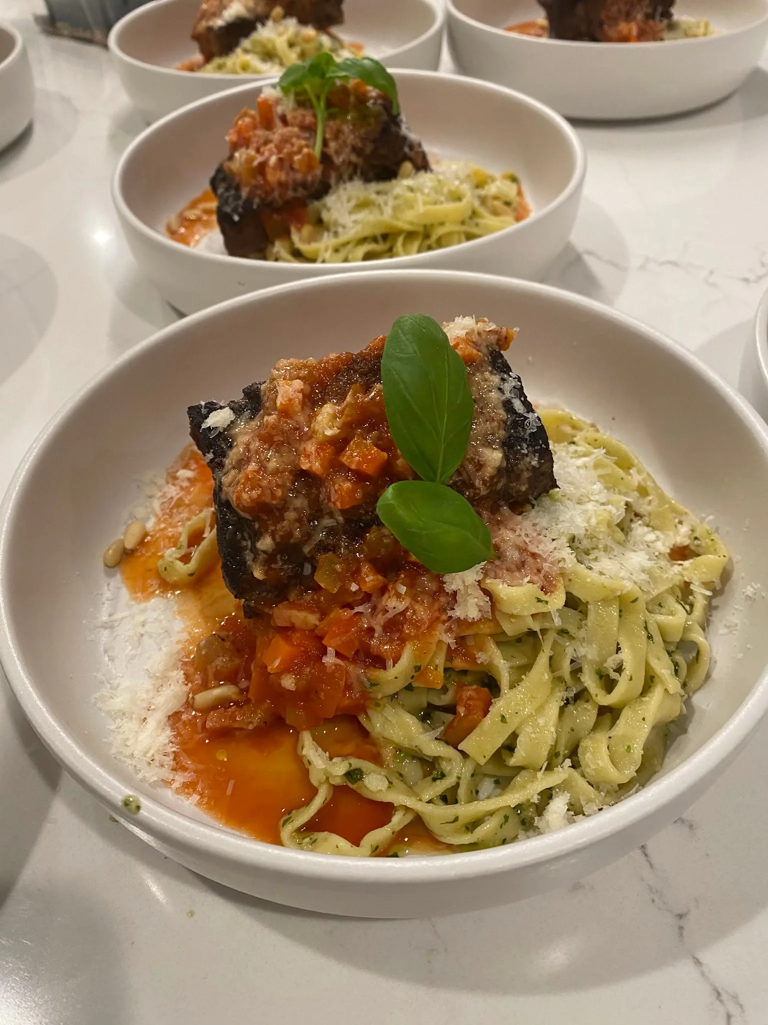 Braised short rib over pesto tagliatelle by Monarch Culinary