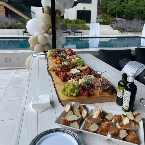 Poolside grazing table with cheeseboards, breads and olive oil at a Monarch Culinary catered event