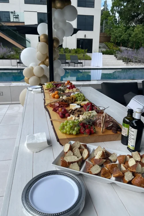 Poolside grazing table with cheeseboards, breads and olive oil at a Monarch Culinary catered event