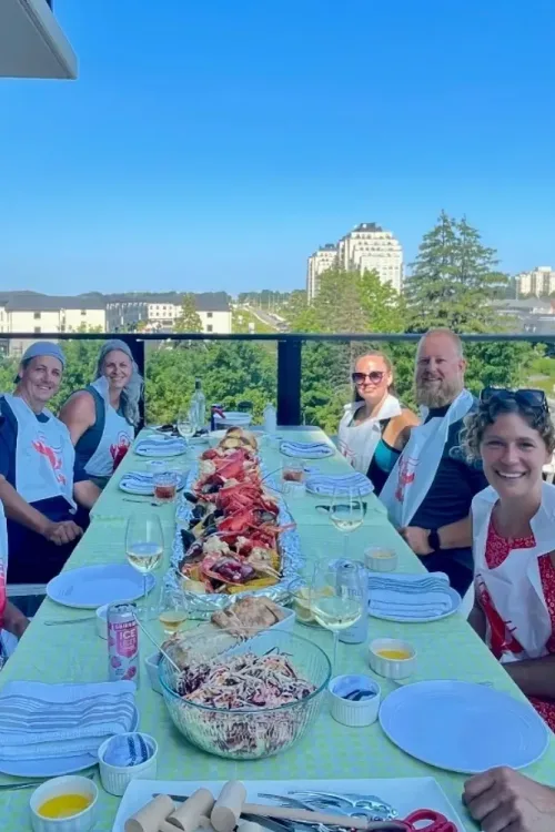 Guests seated at a long rooftop table for a Monarch Culinary catered seafood dinner