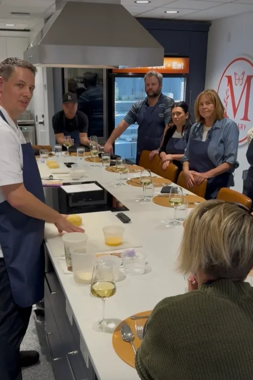 Guests seated at the counter during a cooking class at the Monarch Culinary Studio